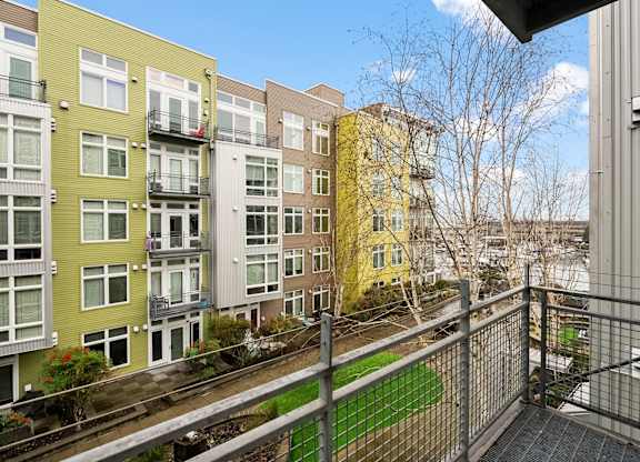 A view of a green and yellow building from a balcony.