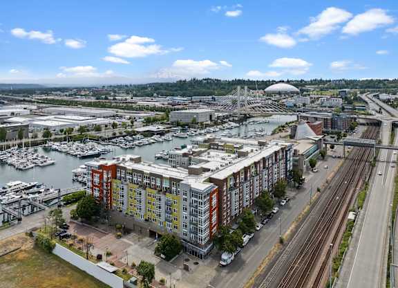 A view of a city with a large building in the foreground and a bridge in the background.