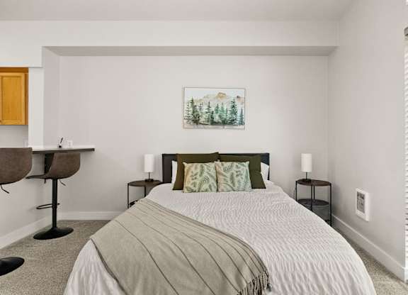 A bedroom with a large bed and a painting on the wall.