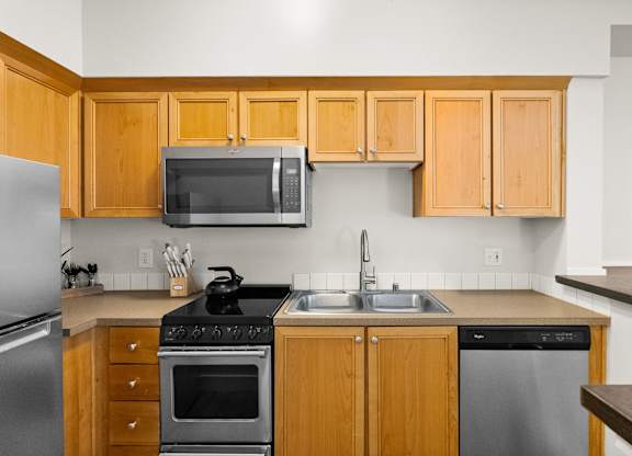 A kitchen with wooden cabinets and stainless steel appliances.