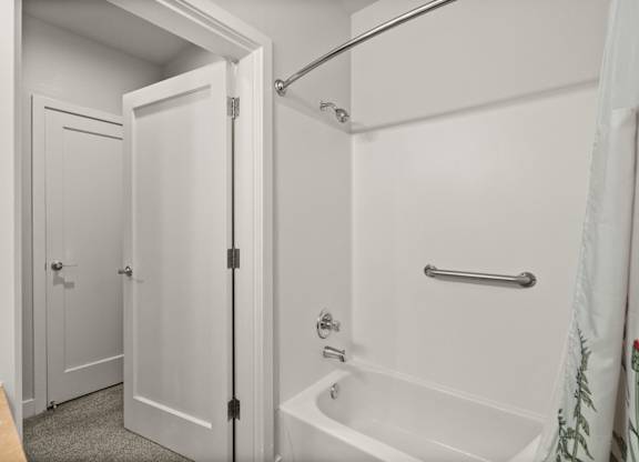A white bathroom with a tub and shower.