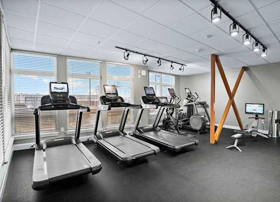 A gym with treadmills, elliptical machines, and other exercise equipment.