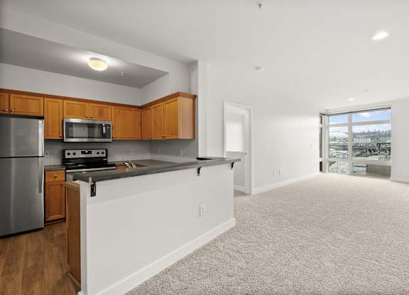 A kitchen with wooden cabinets and a stainless steel refrigerator.