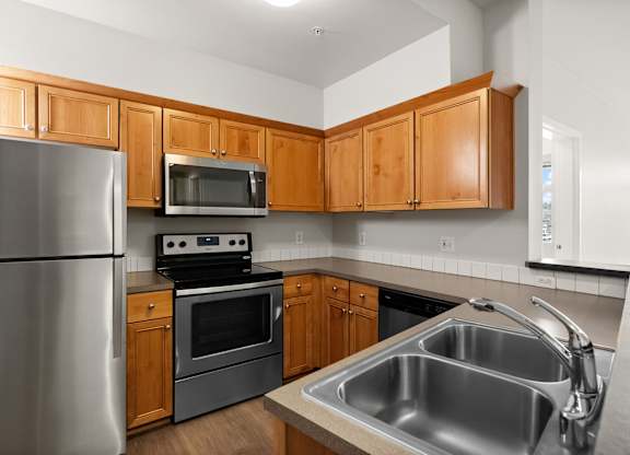A kitchen with wooden cabinets and stainless steel appliances.
