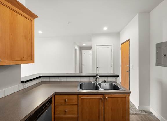 A kitchen with wooden cabinets and a stainless steel sink.