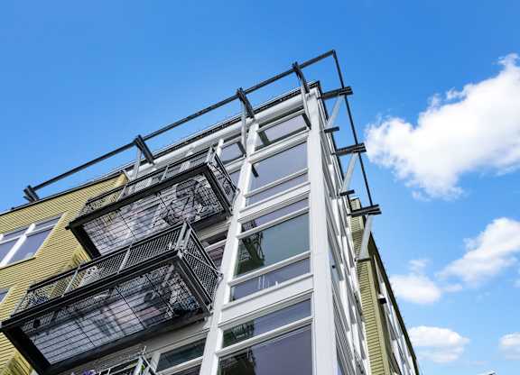 A modern building with a balcony and a metal railing.