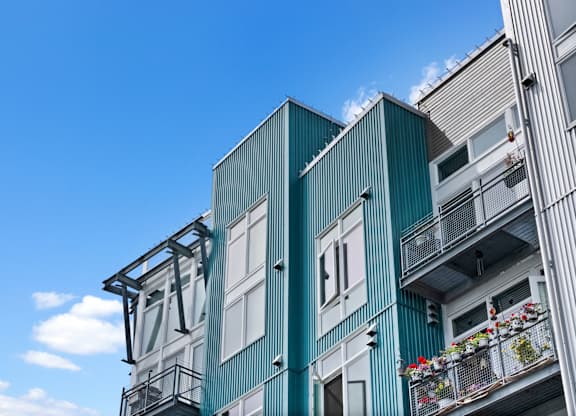 A modern building with balconies and flower pots.