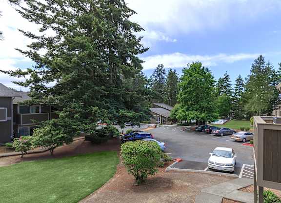 A parking lot with cars and a building in the background.