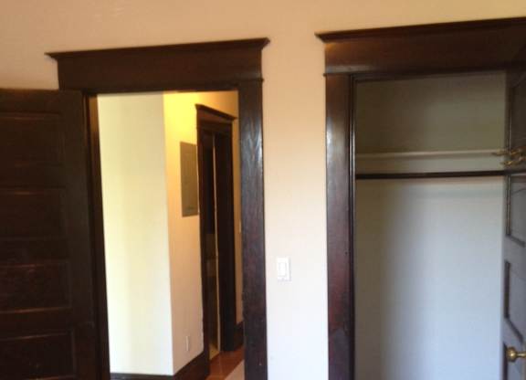 A room with a wooden floor and a white wall.