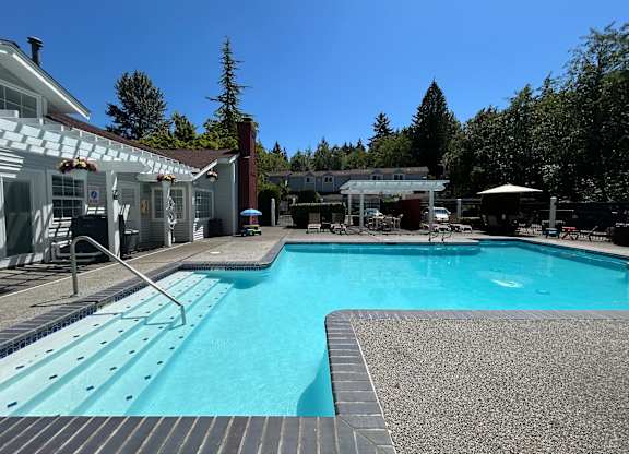A swimming pool with a slide and a building in the background.
