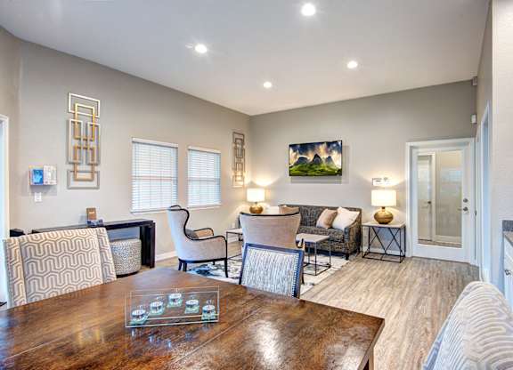A well-lit living room with a dining table and chairs.