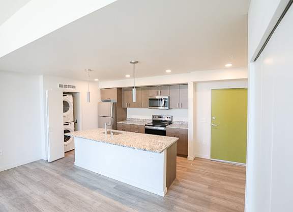 A kitchen with a white island in the middle of the room.