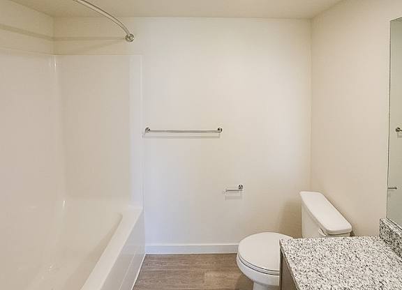 A white bathroom with a toilet, sink, and shower.