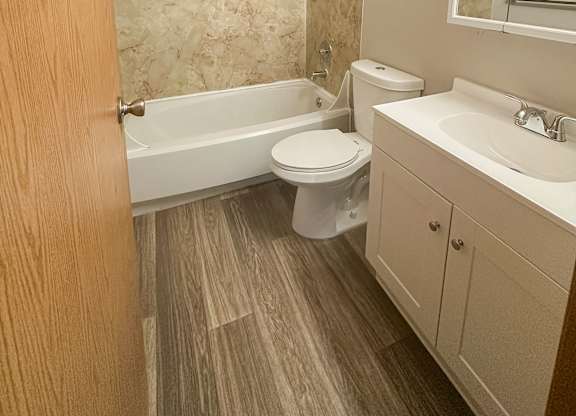 A bathroom with a toilet, sink, and bathtub.