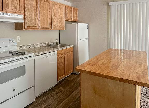 A kitchen with wooden cabinets and a white refrigerator.
