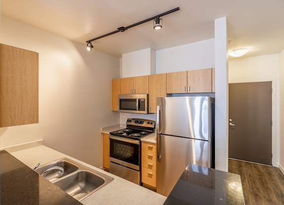 A modern kitchen with stainless steel appliances and wooden cabinets.