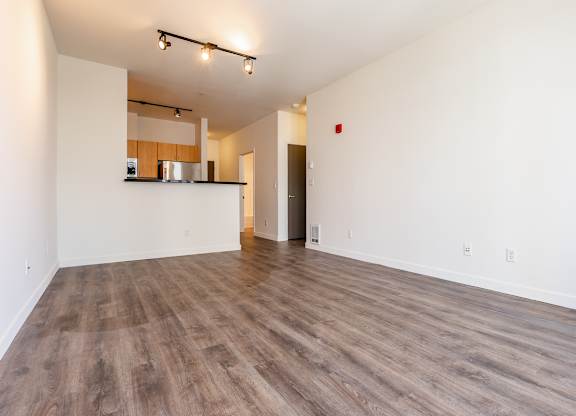 A room with wooden flooring and white walls.