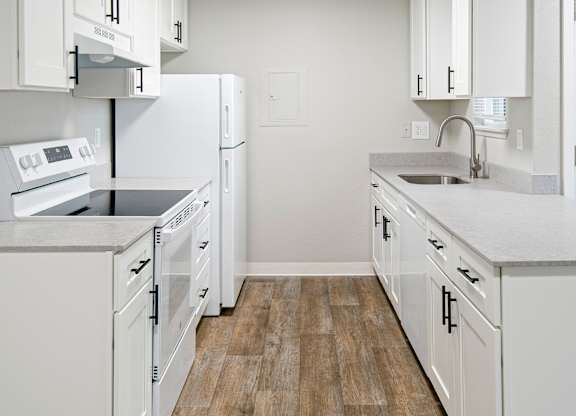 A kitchen with white appliances and cabinets.