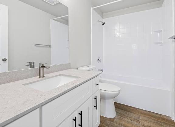 A white bathroom with a sink, toilet, and bathtub.