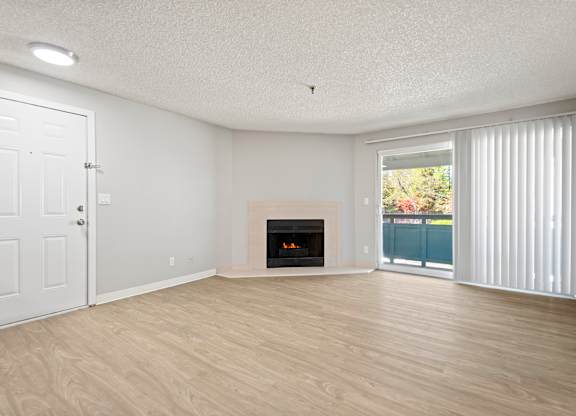 A room with a fireplace and sliding glass doors.