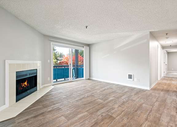 A modern living room with a fireplace and sliding glass doors.