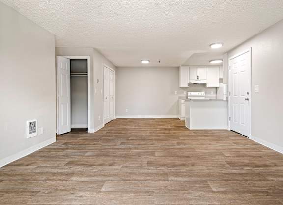 A kitchen area with a refrigerator, cabinets, and a countertop.