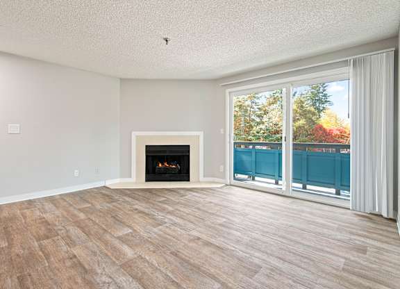 A room with a fireplace and sliding glass doors.