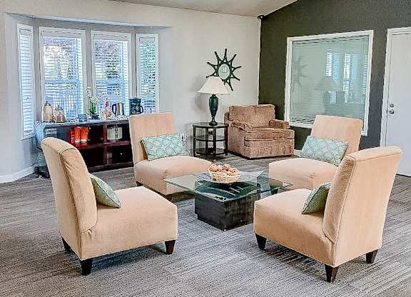 A living room with a glass table and four chairs.