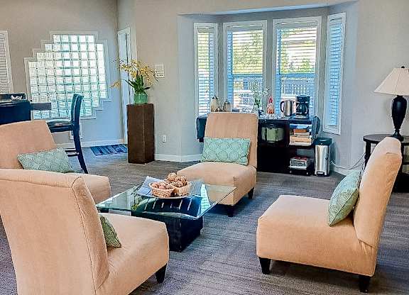 A living room with a glass table and four chairs.
