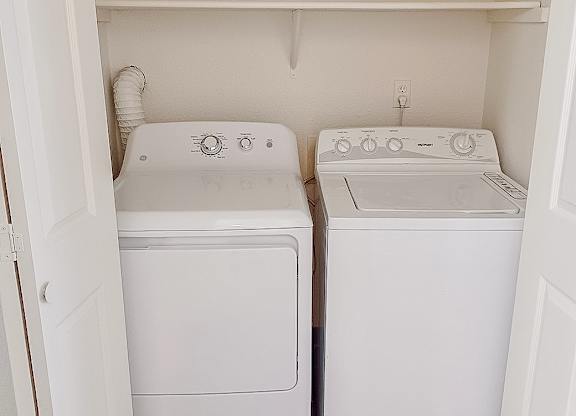 A small laundry room with a washer and dryer.