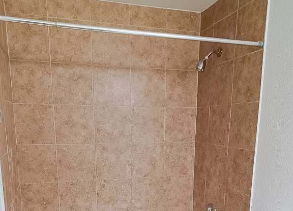 A white toilet sits next to a bathtub in a bathroom.