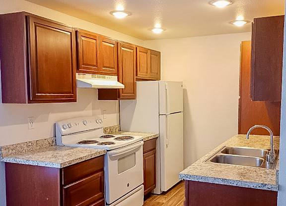 A kitchen with wooden cabinets and a white refrigerator.
