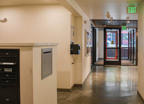 A hallway with a door and exit sign.