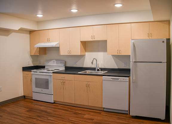 A kitchen with wooden cabinets and white appliances.