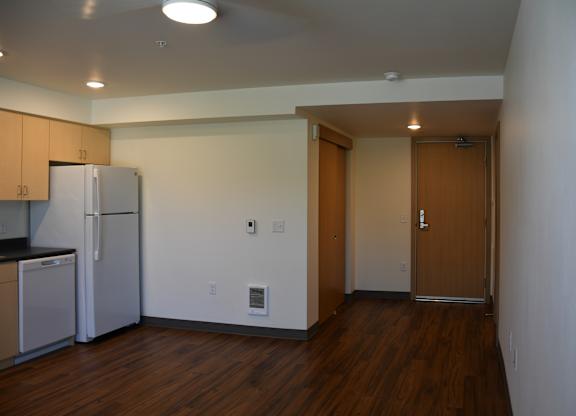 A kitchen with a refrigerator and cabinets.