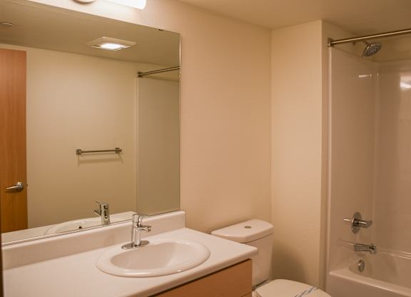 A white bathroom with a sink, toilet, and bathtub.