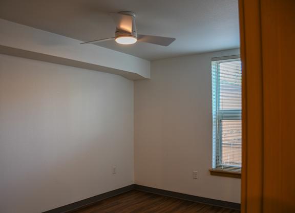 A room with a ceiling fan and a window.