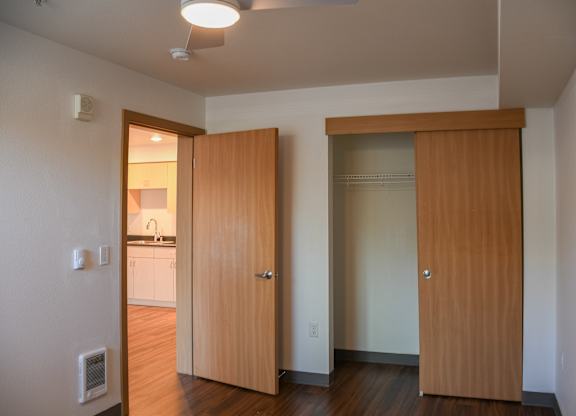 A kitchen is visible through a doorway in a room.
