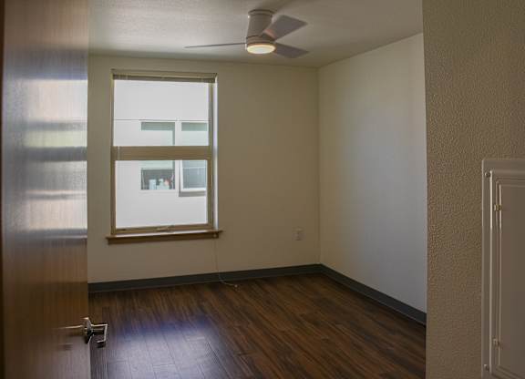 A room with a window and a ceiling fan.