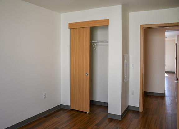 A room with a wooden door and a white wall.