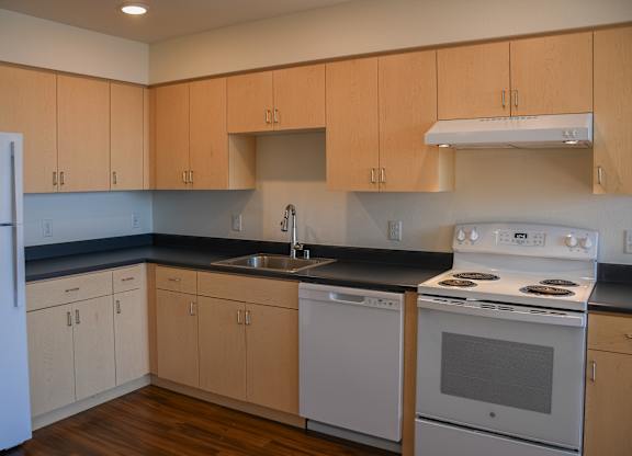 A kitchen with wooden cabinets and white appliances.