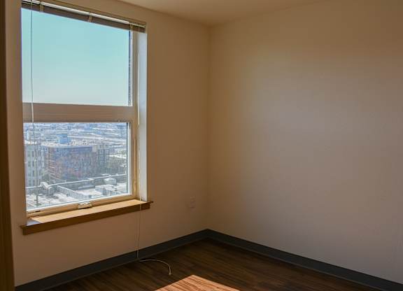A room with a window overlooking a cityscape.