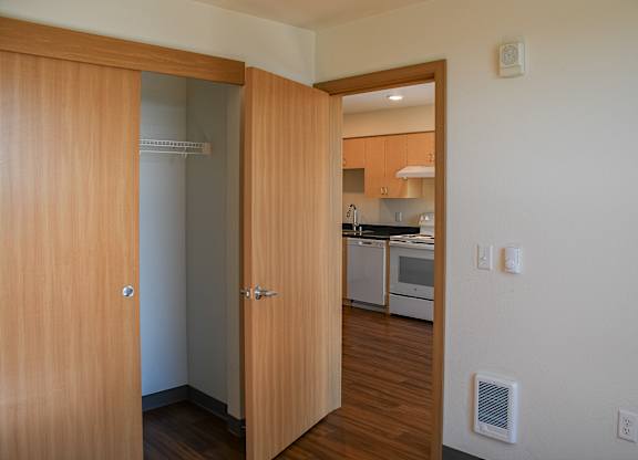 A kitchen is visible through a doorway.