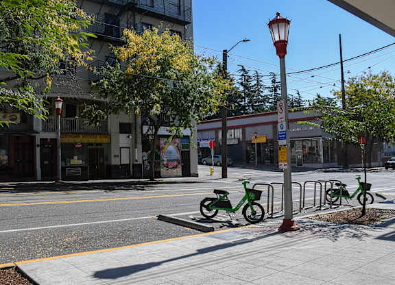 A street scene with a red and yellow street light and a green bike.