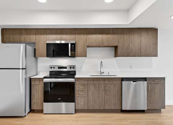Kitchen area with wood cabinets at Victory Northgate Apartments, Seattle