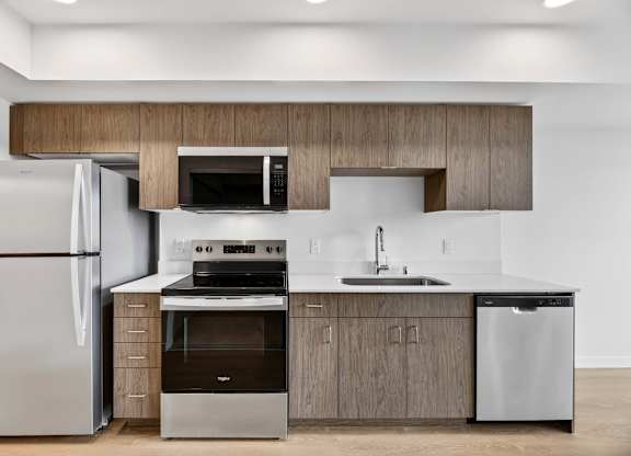 Stainless steel appliances and white countertops at Victory Northgate Apartments, Seattle, Washington