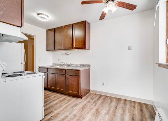 A kitchen with a white fridge and wooden cabinets.