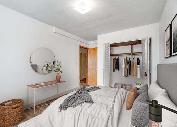 A bedroom with a bed, a mirror, a dresser, and a basket.