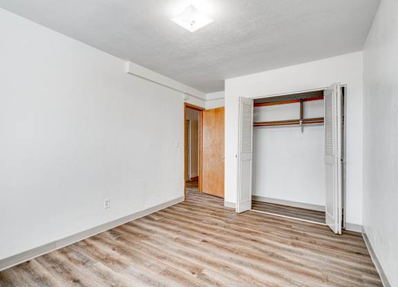 A room with a white wall and a wooden floor.