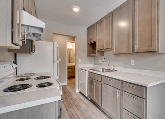 A kitchen with a white stove top oven and a white counter top.